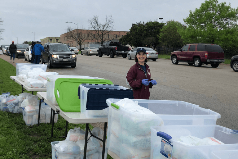 Allison smiles at a CCCTX material distribution event serving the community in the early days of the COVID-19 pandemic.
