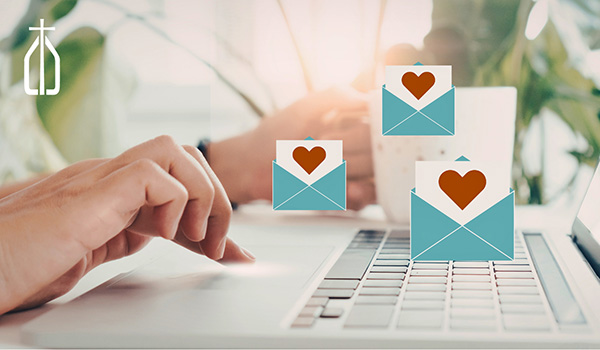 hands typing emails with heart